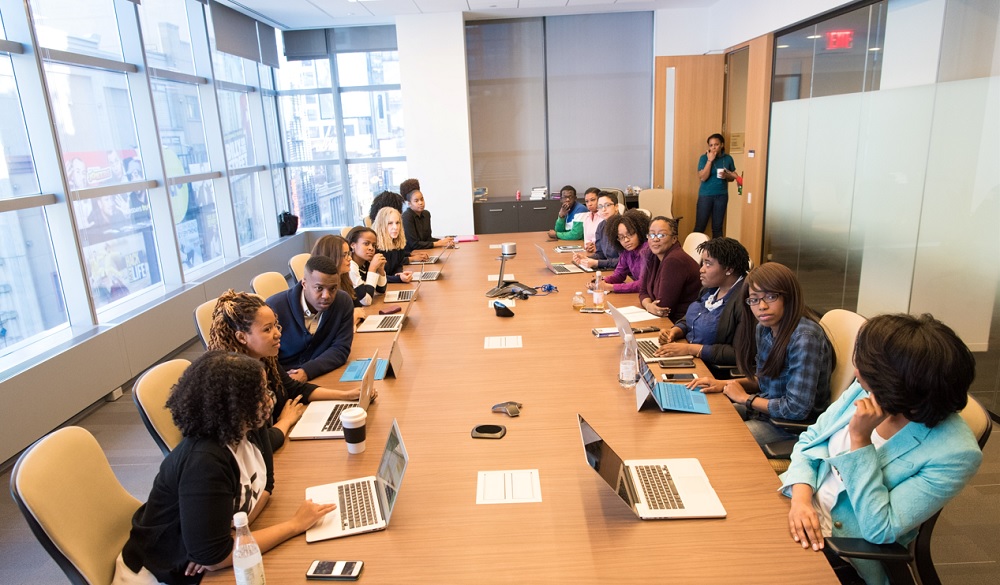 Photo of a diverse group of people sitting at a board table and having a discussion 