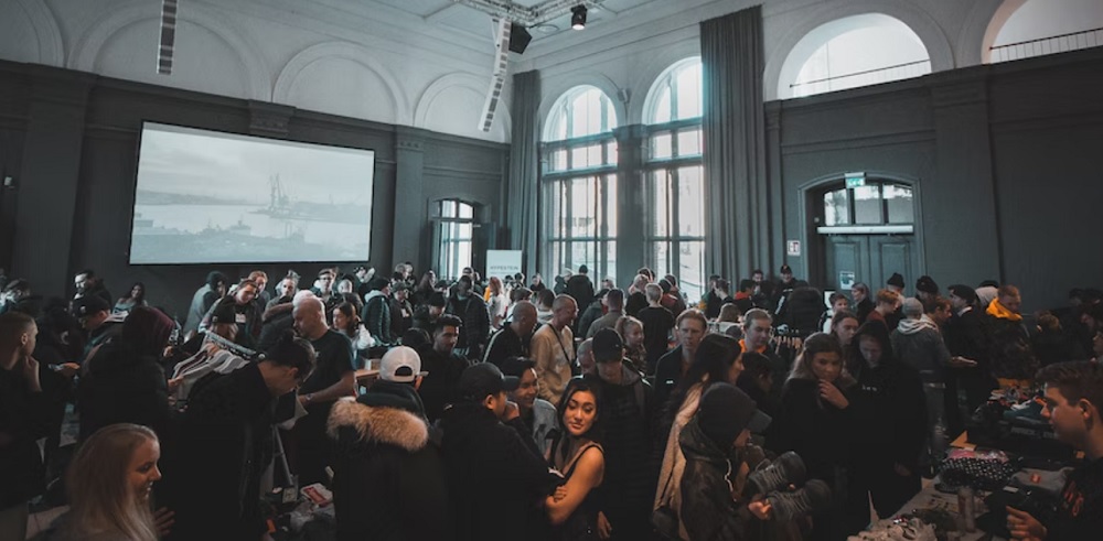 Photo of a big group of people at an event in a room with high ceilings